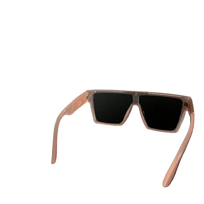 Square-frame sunglasses with a translucent pink frame and black lenses, resting on a dark wooden table in an indoor setting.